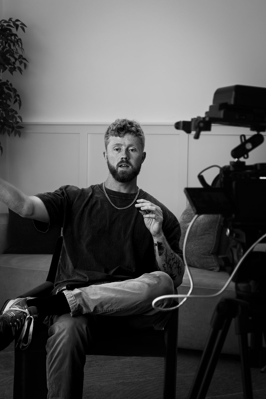 Kyle, founder of Red Crate Rentals, seated and talking on an interview set, with a cinema camera rig on a tripod in the foreground